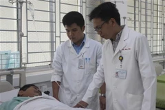 Bác sỹ Trần Viết Bảo và bác sỹ Nguyễn Huy Phú (ngoài cùng) đã hiến máu trong ca mổ để cứu sống bệnh nhân nguy kịch do mất nhiều máu. (Ảnh: Lê Xuân/TTXVN)