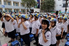 Các em học sinh trường Tiểu học Ba Đình, Hà Nội, đội mũ bảo hiểm. (Ảnh: Trần Việt/TTXVN)