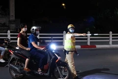 Sau khi hết giãn cách, nhiều người ra đường thường chủ quan mắc lỗi không đội mũ bảo hiểm khi tham gia thông. Các trường hợp này đều được lực lượng chức năng dừng xe và lập biên bản xử lý. (Ảnh: Phạm Kiên/TTXVN)
