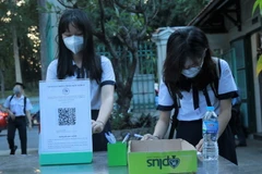 Học sinh Trường THPT Lê Quý Đôn (quận 3) khai báo y tế ở khu vực ngoài cổng trường. (Ảnh: Thu Hoài/TTXVN)
