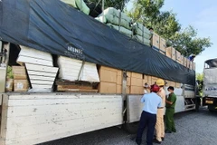 Lực lượng chức năng kiểm tra hàng hóa trên xe. (Ảnh: TTXVN phát)