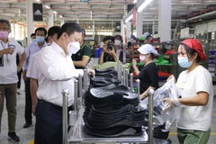 Phó Chủ tịch UBND Thành phố Hồ Chí Minh Dương Anh Đức thăm hỏi công nhân tại các chuyền sản xuất của Công ty Trách nhiệm hữu hạn Pouyuen Việt Nam ở quận Bình Tân. (Ảnh: Thanh Vũ/TTXVN)