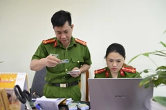 Trả căn cước công dân gắn chip điện tử cho người dân. (Ảnh: Xuân Tư/TTXVN)
