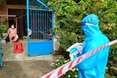 Bác sỹ Lê Thuấn Kiệt, Trạm y tế xã Thới Thạnh, huyện Thới Lai phát thuốc cho bệnh nhân F0 đang cách ly, điều trị tại nhà. (Ảnh: Thu Hiền/TTXVN)