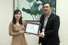 Tiến sỹ Trần Quang Tuấn, Giám đốc Trung tâm Nghiên cứu và Phát triển Truyền thông Khoa học và Công nghệ trao giải cho đại diện nhóm tác giả của Báo điện tử VietnamPlus. (Ảnh: PV/Vietnam+)