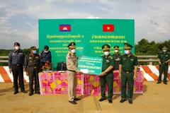 Đại tá Lê Hồng Vương, Chỉ huy trưởng Bộ đội Biên phòng trao Bảng tượng trưng 50 triệu cho Thiếu tướng Chăn Chon, Phó Giám đốc ty Công an tỉnh Srey Veng của Campuchia. (Ảnh: Thanh Tân/TTXVN)