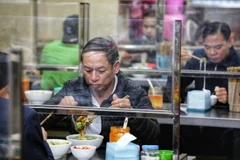 Các cửa hàng ăn uống lắp vách ngăn đảm bảo an toàn phòng chống dịch tạo được cảm giác an tâm cho khách hàng. (Ảnh: Thành Đạt/TTXVN)