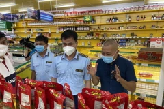 Ông Trương Văn Ba, Cục trưởng Cục Quản lý thị trường Thành phố Hồ Chí Minh (ở giữa) làm việc với đại diện Công ty Bách Hóa Xanh tại một buổi kiểm tra. (Ảnh: Thành Chung/TTXVN)