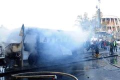 Lực lượng cứu hỏa dập lửa xe buýt chở các quân nhân Syria bị đánh bom ở Damascus, ngày 20/10/2021. (Ảnh: AFP/TTXVN)