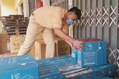 Lực lượng chức năng kiểm đếm số hàng lậu bị bắt giữ. (Ảnh: TTXVN phát)