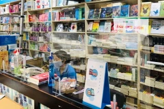 Tại quầy thu ngân ở các gian hàng được lắp đặt vách ngăn giọt bắn. (Ảnh: TTXVN phát)