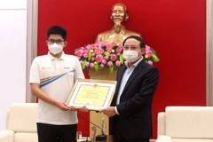 Ông Nguyễn Xuân Ký, Bí thư Tỉnh ủy Quảng Ninh tặng bằng khen cho Nguyễn Hoàng Khánh, nhà vô địch Đường lên đỉnh Olympia năm 2021. (Ảnh: Thanh Vân/TTXVN)