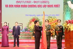 Phó Thủ tướng Thường trực Chính phủ Phạm Bình Minh thực hiện nghi thức trao tặng Huân chương Độc lập hạng Nhất cho Đảng bộ và nhân dân tỉnh Thái Nguyên. (Ảnh: Hoàng Nguyên/TTXVN)