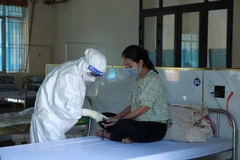 Các bác sỹ đo nồng độ SpO2 cho F0 tại Bệnh viện Dã chiến số 1, tại Trung đoàn 753 khu B, khu 8, xã Trưng Vương, thành phố Việt Trì. (Ảnh: Diệp Trương/TTXVN)