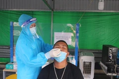 Lấy mẫu test nhanh COVID-19 miễn phí tại chốt kiểm soát cầu Bạch Đằng. (Ảnh: Thanh Vân/TTXVN)