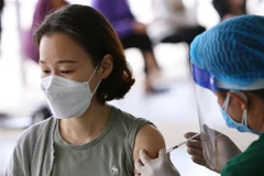Tiêm vaccine phòng COVID-19 cho người nước ngoài. (Ảnh: Hoàng Hiếu/TTXVN)