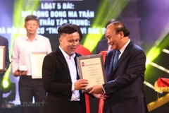 Thủ tướng Nguyễn Xuân Phúc trao giải A, Giải Báo chí Quốc gia lần thứ XIV-năm 2020 cho đại diện nhóm tác giả Báo Điện tử VietnamPlus. (Ảnh: Nguyên An/Vietnam+)