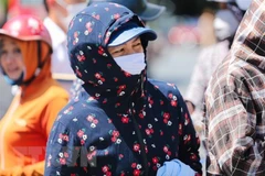 Người dân cần che chắn cẩn thận khi ra ngoài trời nắng nóng. (Ảnh: Bích Huệ/TTXVN)