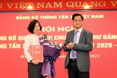 Ông Huỳnh Tấn Việt, Ủy viên Ban Chấp hành Trung ương Đảng, Bí thư Đảng ủy Khối các cơ quan Trung ương trao quyết định của Ban thường vụ Đảng ủy Khối các cơ quan Trung ương cho bà Vũ Việt Trang, Tổng Giám đốc TTXVN, Bí thư Đảng ủy TTXVN. (Ảnh: Thành Đạt/TT