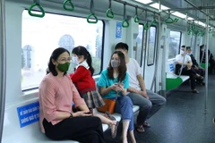 Một gia đình đi tàu Cát Linh-Hà Đông trong ngày đầu khai thác thương mại. (Ảnh: Hoàng Hiếu/TTXVN)