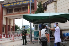 Lực lượng chức năng kiểm tra y tế đối với người vào khu vực cửa khẩu Chi Ma. (Ảnh: Quang Duy/TTXVN)