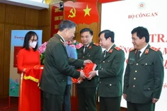 Bộ trưởng Bộ Công an Tô Lâm tặng sách cho các đại biểu. (Ảnh: Văn Điệp/TTXVN)