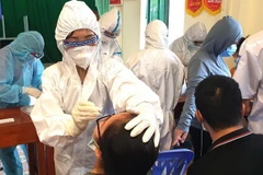Cán bộ y tế lấy mẫu xét nghiệm người dân. (Ảnh: Minh Tâm/TTXVN)