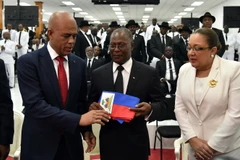 Cựu Tổng thống Haiti Michel Martelly (trái) chuyển giao biểu tượng quyền lực cho ông Jocelerme Privert. (Ảnh: AFP/TTXVN)