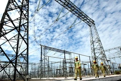 Công nhân EVN đi kiểm tra độ an toàn của trạm biến áp. (Ảnh: Ngọc Hà/TTXVN)