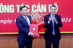 Đồng chí Lê Minh Hưng, Ủy viên Bộ Chính trị, Bí thư Trung ương Đảng, Trưởng Ban Tổ chức Trung ương trao Quyết định, tặng hoa chúc mừng đồng chí Nguyễn Khắc Thận. (Ảnh: Thế Duyệt/TTXVN)