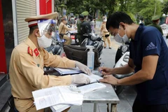 Lực lượng chức năng Hà Nội xử phạt người vi phạm ngày 23/8. (Ảnh: Trần Việt/TTXVN)
