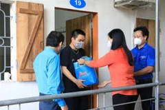 Chủ tịch Ủy ban Mặt trận Tổ quốc Việt Nam thành phố Hà Nội Nguyễn Lan Hương trao quà cho sinh viên tại các khu ở trọ. (Ảnh: Nguyễn Thắng/TTXVN)