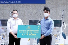 Đại diện Công ty Phú Long (trái) trao tặng Hội Đông y Thành phố Hồ Chí Minh 1,7 tỷ đồng. (Ảnh: Xuân Khu/TTXVN)