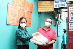 Đại diện Ủy ban MTTQ Việt Nam TP trao quà cho lao động nghèo, gặp khó khăn do ảnh hưởng dịch bệnh COVID-19 tại phường Hiệp Thành, Quận 12. (Ảnh: Xuân Khu/TTXVN)