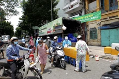 Trước thông tin giãn cách xã hội mới, nhiều người dân thành phố tranh thủ mua hàng hóa bình ổn giá trên đường Tháp Mười (Quận 6). (Ảnh: Thanh Vũ/TTXVN)