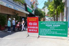 Kiểm tra giấy ra vào khu vực "vùng xanh" tại điểm chốt khu dân cư Xuân Đán 3 (Đà Nẵng) để hạn chế lạ ra vào nhằm phòng chống dịch. (Ảnh: Trần Lê Lâm/TTXVN)