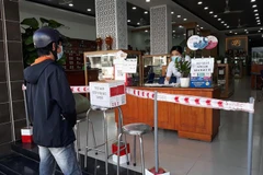 Người dân thành phố Phan Rang-Tháp Chàm tuân thủ các biện pháp phòng, chống dịch COVID-19 khi đi đến nhà thuốc. (Ảnh: Nguyễn Thành/TTXVN)