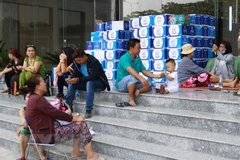 Người dân sinh hoạt tạm cư tại tòa nhà City Gate sau vụ cháy. (Ảnh: Thanh Vũ/TTXVN)