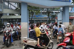 Phụ huynh đưa đón học sinh gây ra cảnh lộn xộn trước trường tiểu học Bành Văn Trân (quận Tân Bình). (Ảnh: Hoàng Hải/TTXVN)