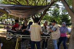 Hỗ trợ người bị thương sau động đất, sóng thần tấn công thành phố Palu, đảo Sulawesi, Indonesia ngày 30/9. (Ảnh: THX/ TTXVN)