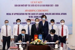 Ký kết bản ghi nhớ về hợp tác thúc đẩy các tiêu chuẩn lao động quốc tế tại Việt giai đoạn 2021-2030. (Ảnh: PV/Vietnam+)