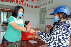 Trao tiền hỗ trợ cho người bán vé số tại thành phố Cần Thơ. (Ảnh: TTXVN)