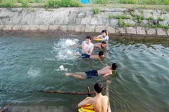 Hướng dẫn trẻ em kỹ năng bơi lội. (Ảnh: Thanh Thủy/TTXVN)