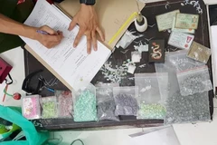 Cơ quan công an kiểm kê tang vật khi triệt phá một lò sản xuất ma túy tổng hợp. (Ảnh minh hoạ: TTXVN)