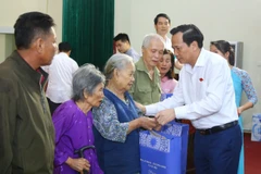 Bộ trưởng Đào Ngọc Dung trao tặng quà cho các gia đình chính sách, người có công. (Ảnh: PV/Vietnam+)