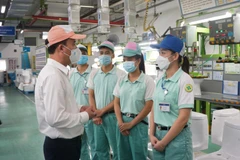 Tổng Giám đốc Bảo hiểm xã hội Việt Nam Nguyễn Thế Mạnh kiểm tra việc hỗ trợ người lao động tại Công ty ToTo Việt Nam. (Ảnh: PV/Vietnam+)
