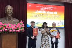 Cục trưởng Cục Văn hóa Cơ sở (giữa) trao giải Nhất cho các tác giả. (Ảnh: PV/Vietnam+)