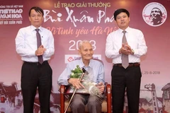 Ông Nguyễn Bá Đạm (giữa) nhận Giải thưởng Lớn-Vì tình yêu Hà Nội trong hệ thống Giải thưởng Bùi Xuân Phái-Vì tình yêu Hà Nội năm 2018. (Ảnh: TTXVN)