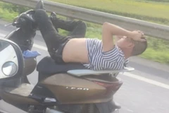 Nam thanh niên nằm hẳn trên yên xe (Ảnh cắt từ clip) 