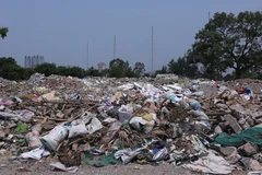 Rác, vật liệu xây dựng dở chất ngổn ngang có ngọn (Ảnh: Minh Sơn/Vietnam+) 